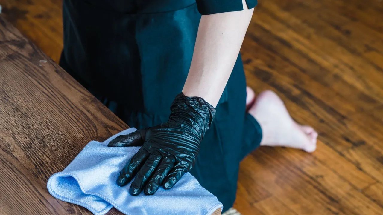 Professional cleaner wiping hardwood floors before a deep clean in Seattle.